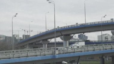 Tren penceresinden şehir manzarası. Arabalı köprü inşaatları. Arkaplanda gökdelenler.