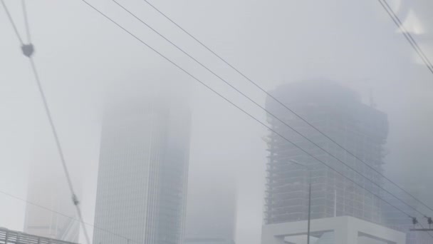 Przemysłowy widok z okna pociągu. Mgła w całym mieście ze skyscapes. — Wideo stockowe