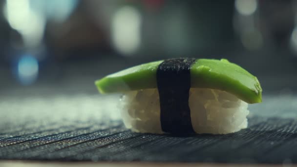 Palos tomando sushi vegetariano de la mesa, Primer plano de comer sushi vegano lleno de aguacate. Restaurante de sushi, comida a domicilio. — Vídeos de Stock