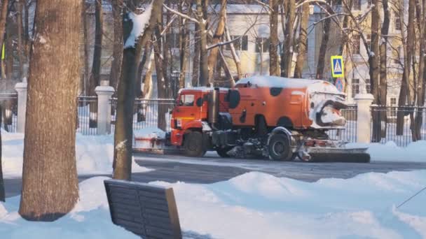 Naranja arados de nieve de la ciudad en movimiento en la calle de la ciudad en el invierno — Vídeos de Stock