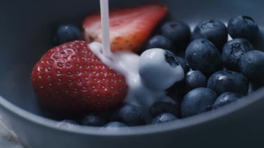 Doğal organik süt ya da yoğurdu taze organik meyve ve böğürtlenlerin sağlıklı karışımıyla seramik kaseye dök.. 