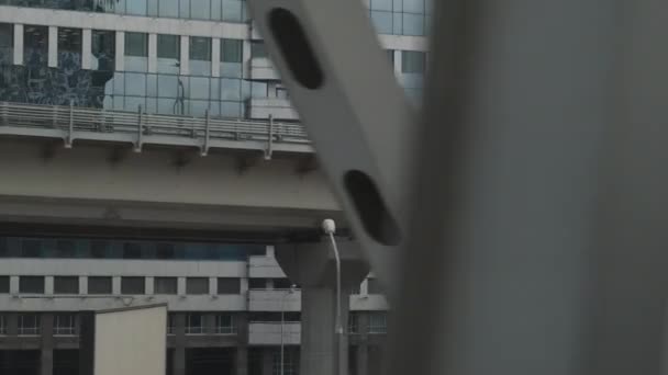 電車の窓から都市の景色。車と道路との橋の建設。背景の高層ビル. — ストック動画