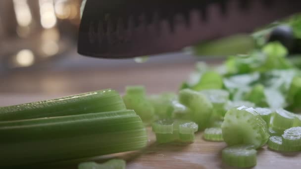 Резка сельдерея с помощью кухонного ножа на деревянной доске, свежий здоровый сельдерей для еды и приготовления пищи с органической фермы. — стоковое видео