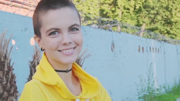 Retrato de mujer joven con el pelo afeitado en el fondo urbano de la calle. — Vídeos de Stock