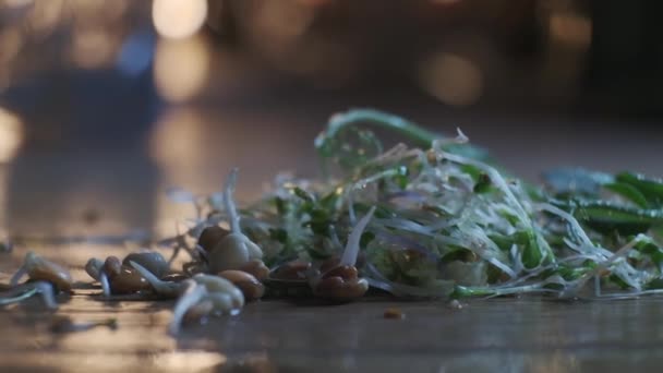 Microgreens y granos germinados en la mesa de madera, vista de cerca en cámara lenta — Vídeos de Stock