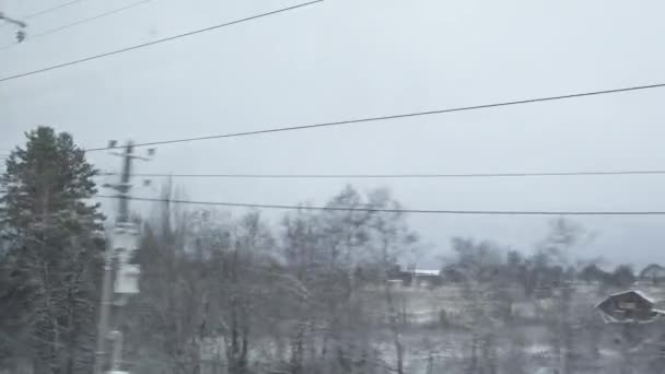 Donmuş ormanlardaki köy boyunca ilerlemek, kış soğuk kırsal tarım arazisi, kar ve buz. Tren penceresinden Pov izleme görüntüsü. — Stok video