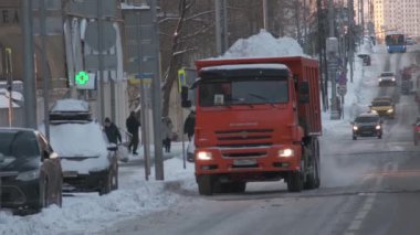 Turuncu şehir kar küreme aracı kışın şehir caddesinde ilerliyor
