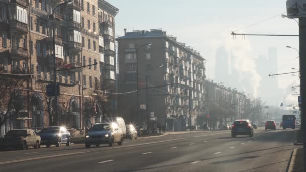 Autos fahren auf breiter Asphaltstraße zwischen städtischen Gebäuden — Stockvideo