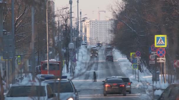 Auto 's rijden langs bevroren straat graafmachine giet sneeuw in de stad — Stockvideo