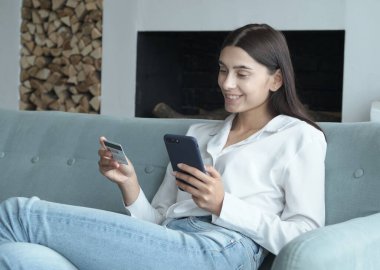 Bankacılık kredi kartını hızlı ve güvenli ödemeler için kullanan mutlu genç bir kadın.. 