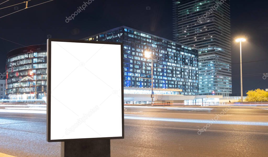 Blank billboard on a busy highway with traffic, neon lights