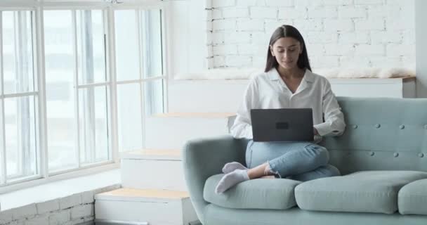 Blogueira feminina cuidadosa usando laptop para escrever posts em redes sociais. — Vídeo de Stock