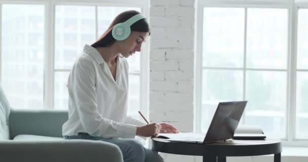 Mujer joven que estudia en línea utilizando la computadora portátil y videollamada con el maestro y el aprendizaje durante el seminario web. — Vídeo de stock