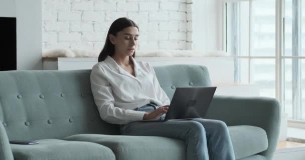 Nachdenkliche junge Freiberuflerin tippt auf Laptop. — Stockvideo