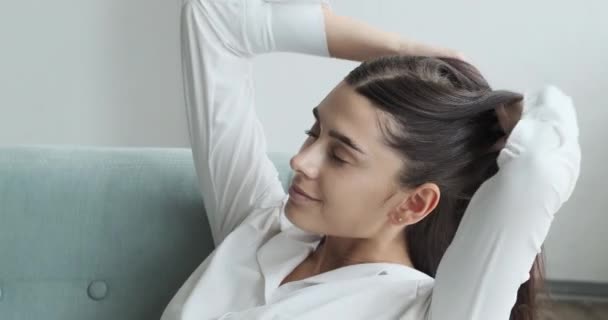 Fiatal nő csukott szemmel, egyedül pihen egy hangulatos nappaliban., — Stock videók