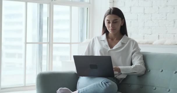 Thoughtful young woman freelancer types on laptop. — Stock Video