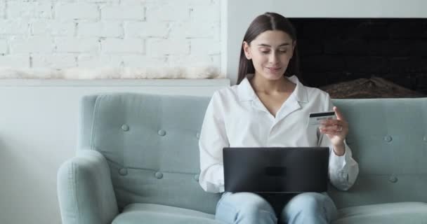 Giovane donna che spende soldi in siti internet e negozi ed effettua pagamenti online. — Video Stock