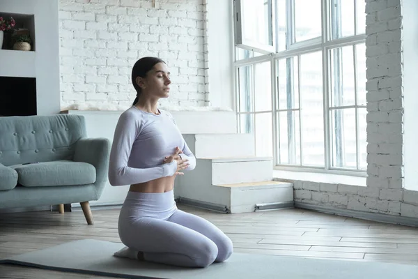 Jong gelukkig vrouw oefenen yoga en doen ademhalingsoefeningen en mediteren. — Stockfoto
