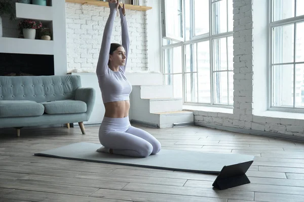 Jonge gelukkige vrouw die online yoga beoefent via videoles en tutorials — Stockfoto