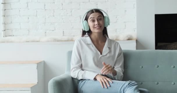 Mulher feliz em fones de ouvido olhando para a câmera, desfrutando de reunião de vídeo com amigos e colegas, conceito de conversa virtual on-line. — Vídeo de Stock