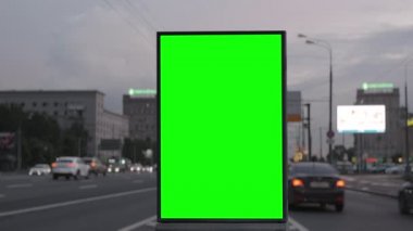 Trafiği, neon ışıkları olan işlek bir otoyolda yeşil ekran reklam panosu