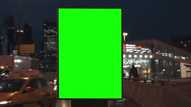 Plakatwand mit grünem Bildschirm auf einer viel befahrenen Autobahn mit Verkehr, Neonlicht — Stockvideo