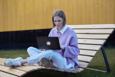 Kablosuz kulaklıklı, serbest çalışan genç bir kadın.