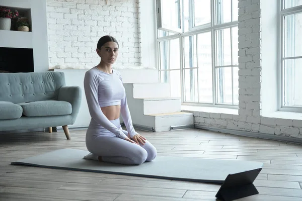 Jonge vrouw mediteren, met behulp van tablet mobiele app voor ademhaling en meditatie — Stockfoto
