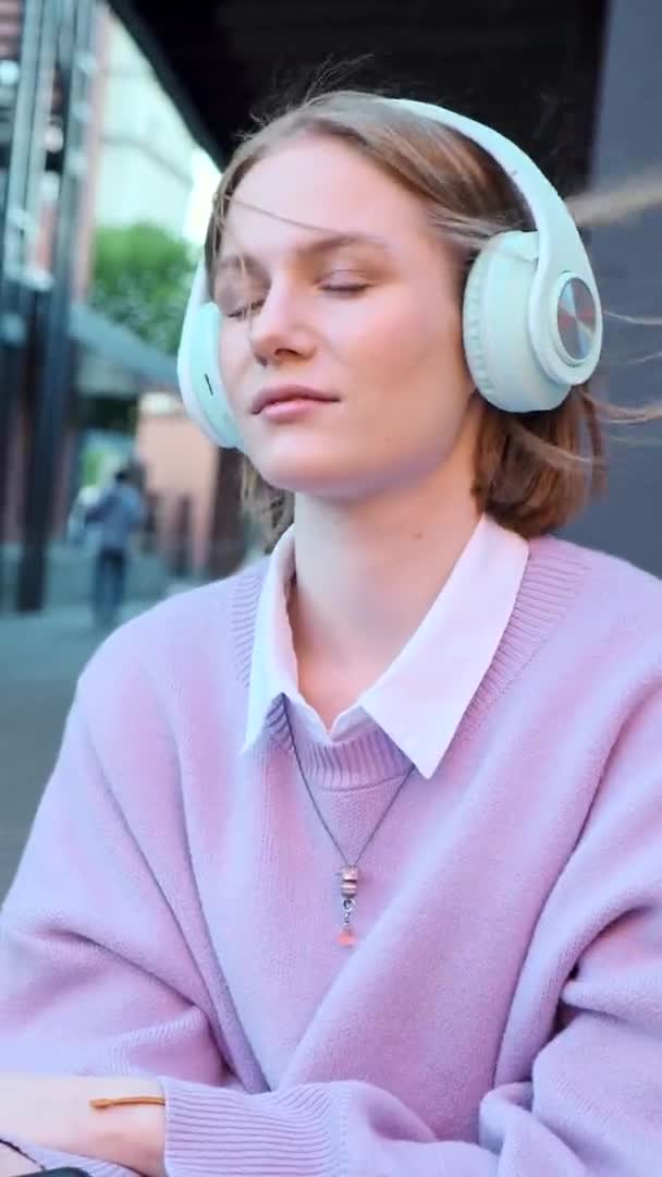 Melancólica estudiante de auriculares escucha música — Vídeos de Stock