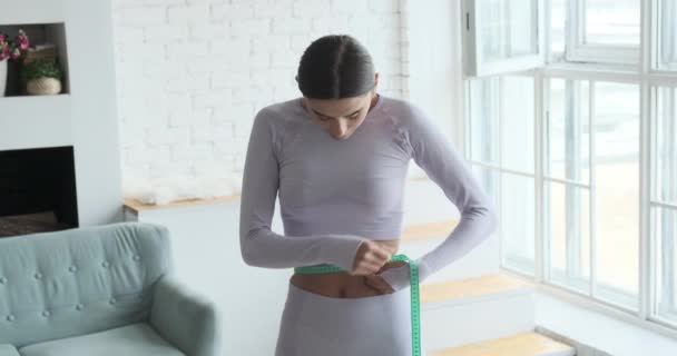 穿着运动衫和腿的女运动员测量腰围 — 图库视频影像