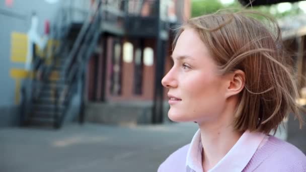 Junge Studentin mit kurzen blonden Haaren vom leichten Wind gewunken — Stockvideo