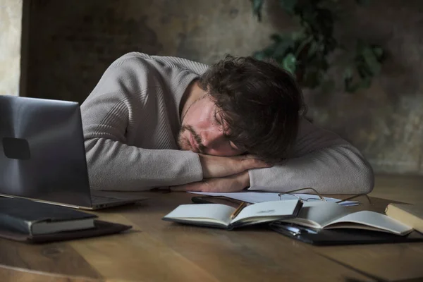 Uitgeputte vermoeide mannelijke freelancer rustend op het werk. — Stockfoto