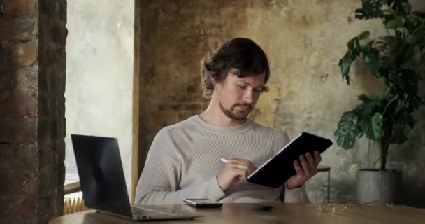 Мужчина-фрилансер использует цифровой планшет с электронным карандашом — стоковое видео