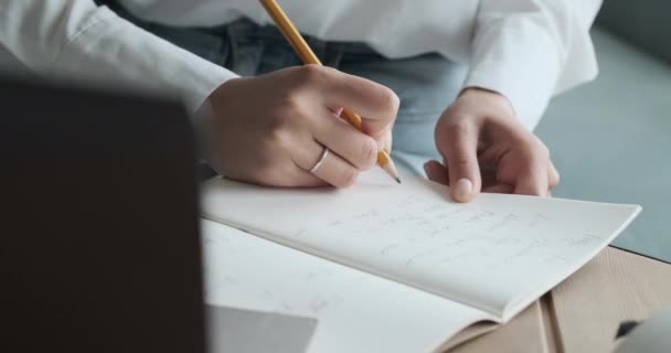Vista de cerca de la mujer joven escribiendo notas y estudiando en línea usando el ordenador portátil con el profesor y el aprendizaje. — Vídeo de stock