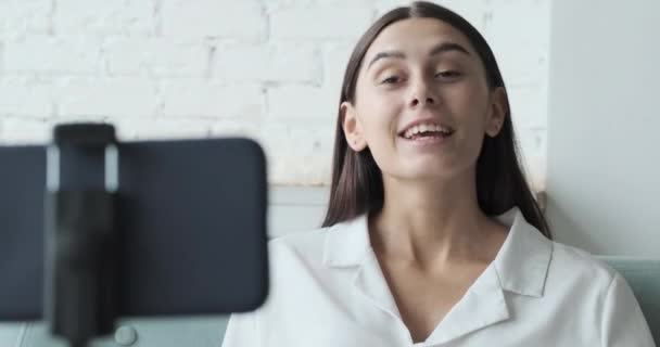 Feminino vlogger conversando em uma chamada de vídeo com amigos usando seu telefone — Vídeo de Stock