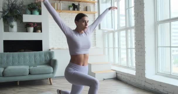 Mujer atlética joven haciendo ejercicio en casa., estirando las piernas, respirando en casa acogedora. — Vídeos de Stock