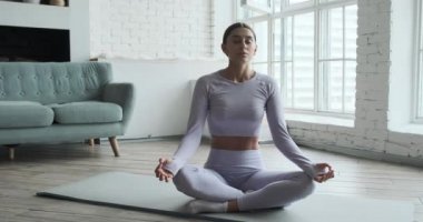 Genç mutlu kadın yoga yapıyor ve nefes egzersizleri yapıyor..