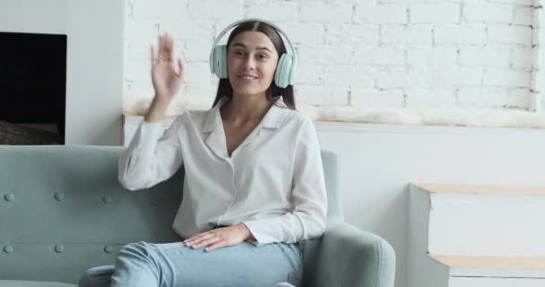 Mulher feliz em fones de ouvido olhando para a câmera, desfrutando de reunião de vídeo com amigos e colegas, conceito de conversa virtual on-line. — Vídeo de Stock