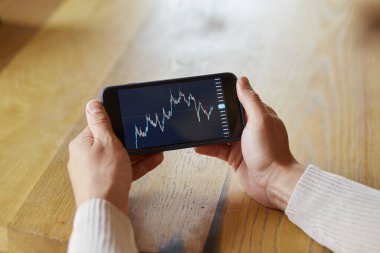 Borsa kripto para birimi bitcoin grafiği ile akıllı telefon kullanan bir işadamı