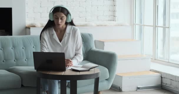 Серйозна молода кавказька жінка, що розмовляє на відео і дивиться на ноутбук.. — стокове відео