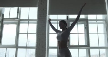 Gri spor takım elbiseli profesyonel yoga uygulayıcısı.
