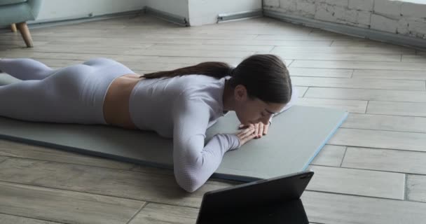 Joven mujer feliz practicando yoga y haciendo ejercicios de respiración viendo videos en vivo aprendiendo clases en tableta. — Vídeos de Stock