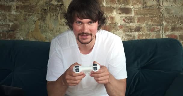 A male freelancer spending his work time playing video games while sitting on a coach. — Stock Video