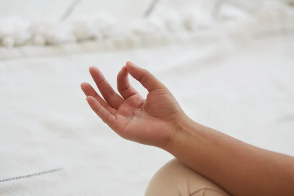 Close-up bijgesneden schot van een Afrikaanse vrouw in actieve dragen doen yoga en mediteren binnen. — Stockfoto