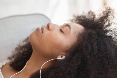 Hoş, melez bir kadın telefonuyla sakinleştirici müzik dinliyor ve olumlu duygulardan etkileniyor.