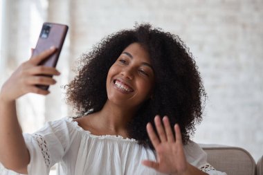 Kadın vlogger etkileyicisi evde oturup kameraya bakıyor.