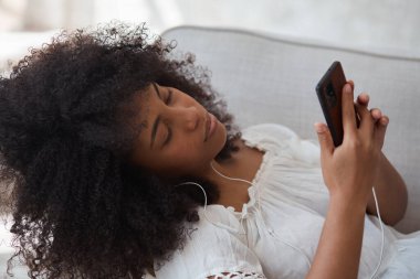 Kanepede oturan siyah bir kız öğrenci ve video görüşmesi yapıyor..