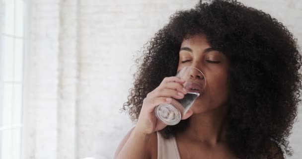 Молодая спортсменка фитнес черная женщина питьевая вода после спортивных тренировок на дому — стоковое видео