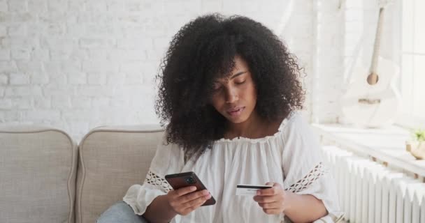 Feliz sonriente afroamericana cliente de banco femenino usando tarjeta para pagos instantáneos — Vídeos de Stock