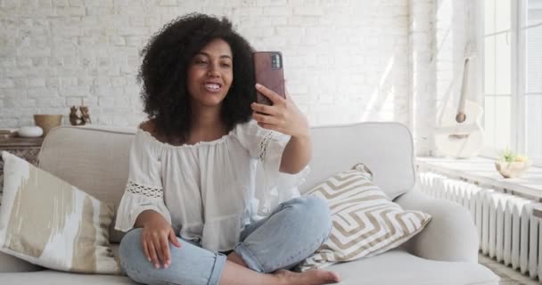 Junge schwarze Frau kommuniziert auf einem Videotelefonat mit Freunden mit ihrem Handy und nimmt ein Aufklärungsvideo auf — Stockvideo